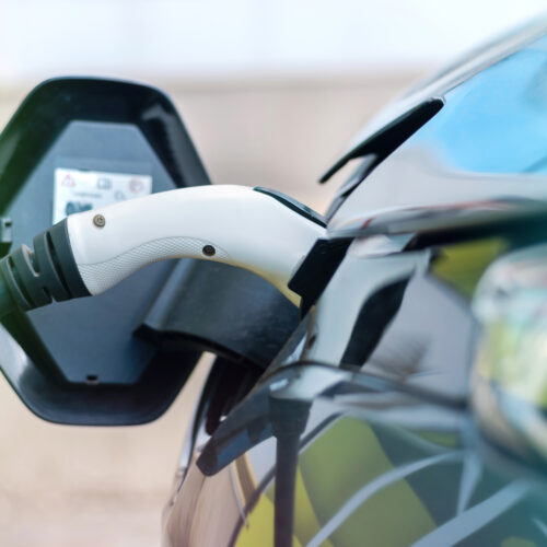 Carro elétrico conectado ao carregador para representar as tendências da mobilidade elétrica Brasil